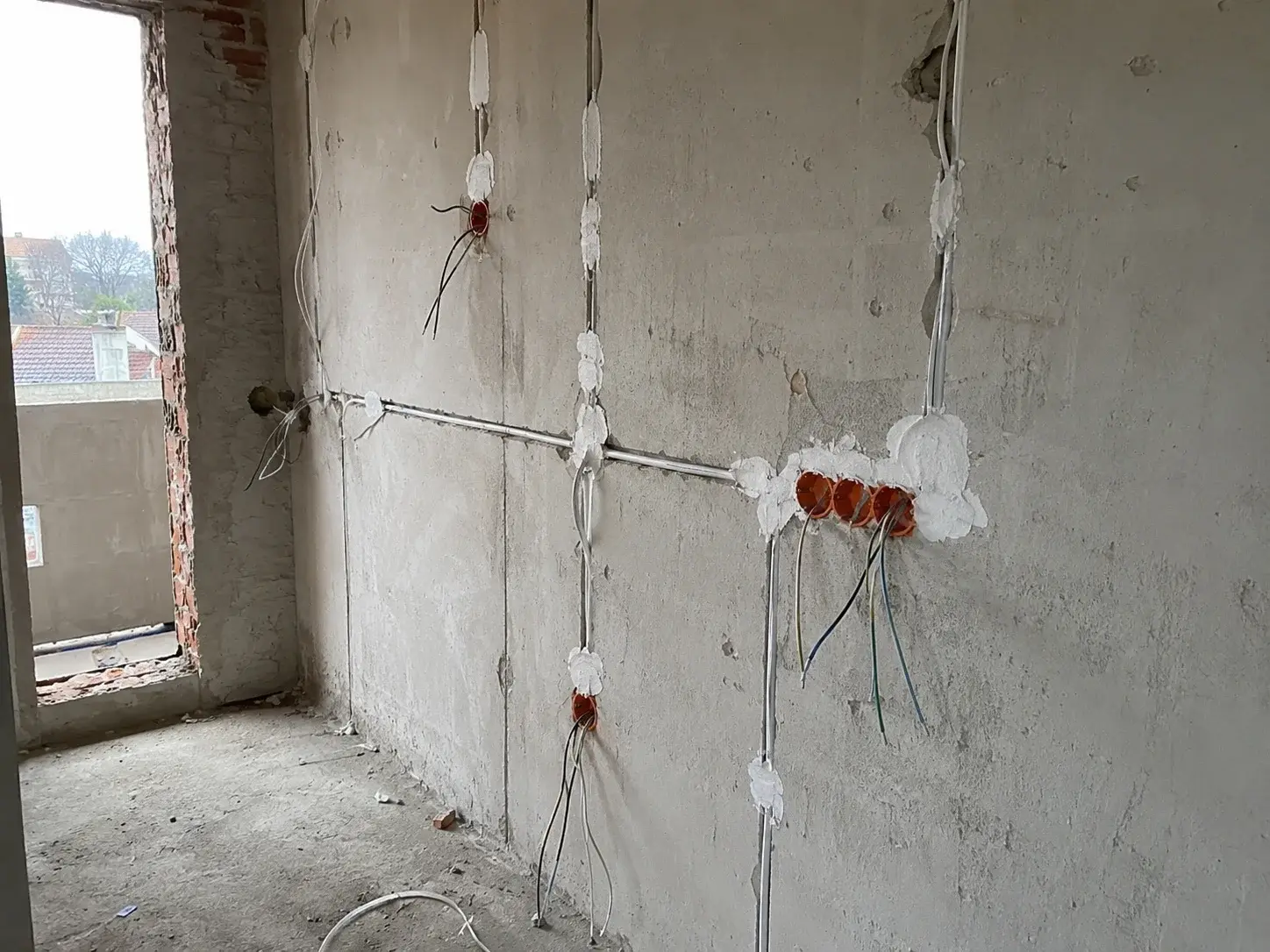 Razvučene instalacione cevi i razvodne kutije na zidu novog stana